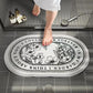 Bathroom scene with a decorative bath mat featuring floral designs and text.