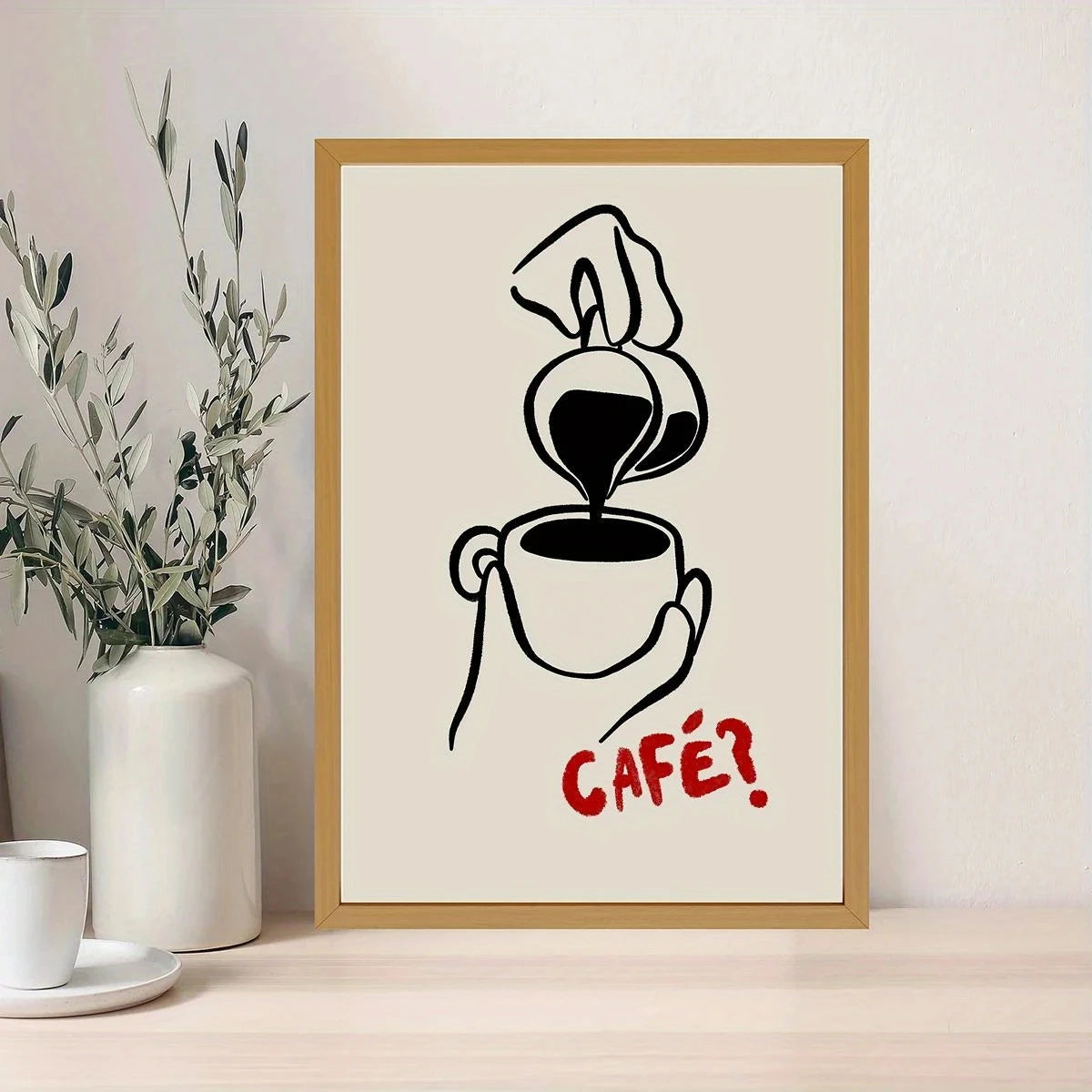 Framed artwork of a coffee cup being poured with 'CAFé!' text on a light background.