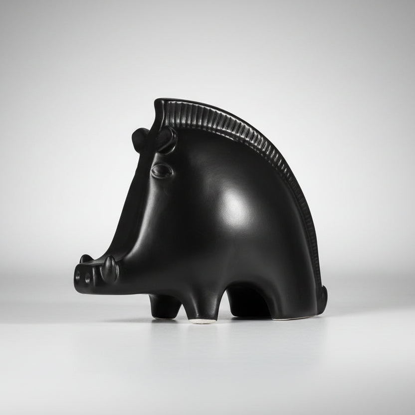 A black and white ceramic wild boar shaped ornament.
