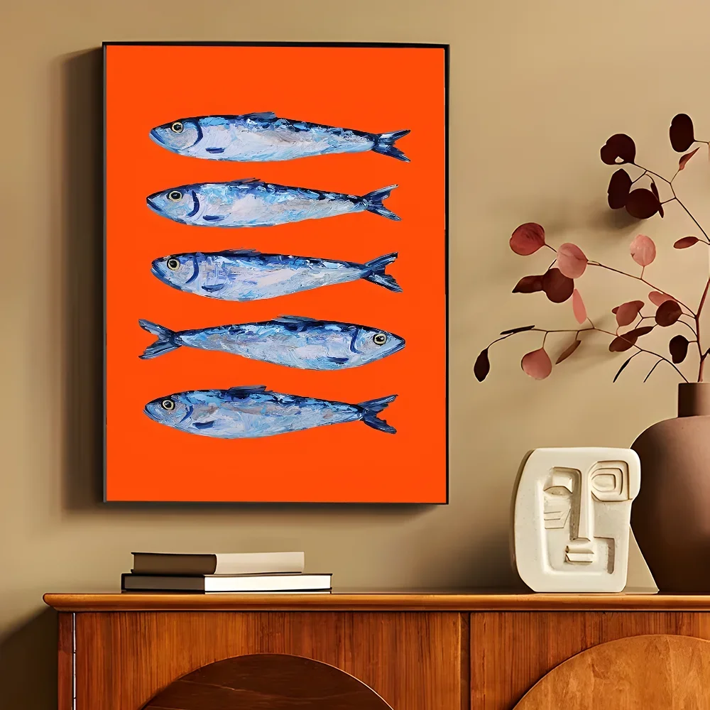 Framed artwork of blue fish on an orange background above a wooden console table.