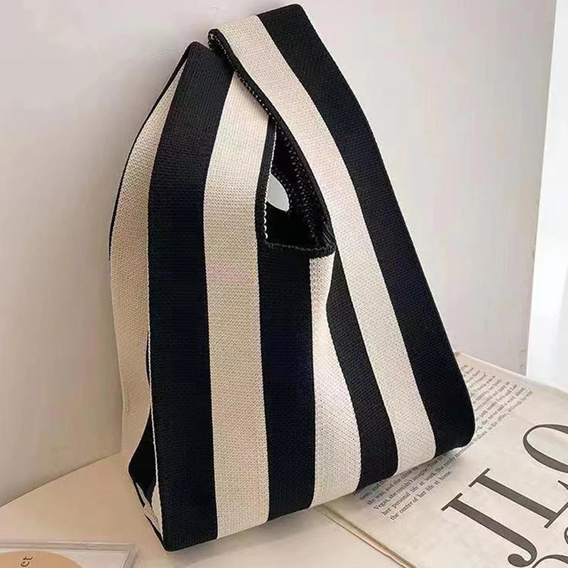 Black and white striped bag on a light surface with a blurred background