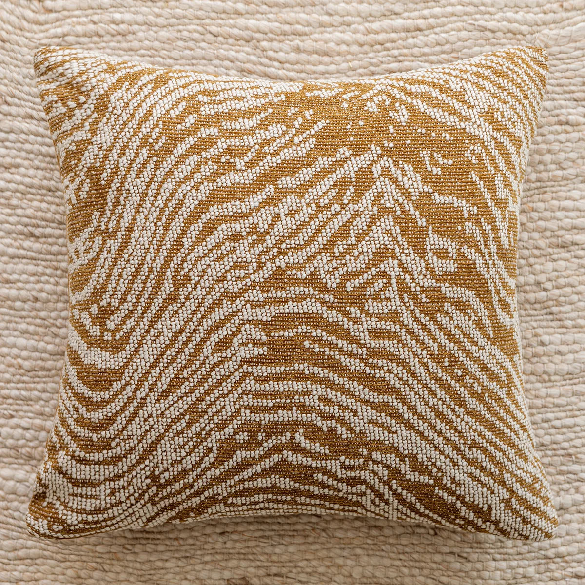 Decorative pillow with brown and beige pattern on a textured surface