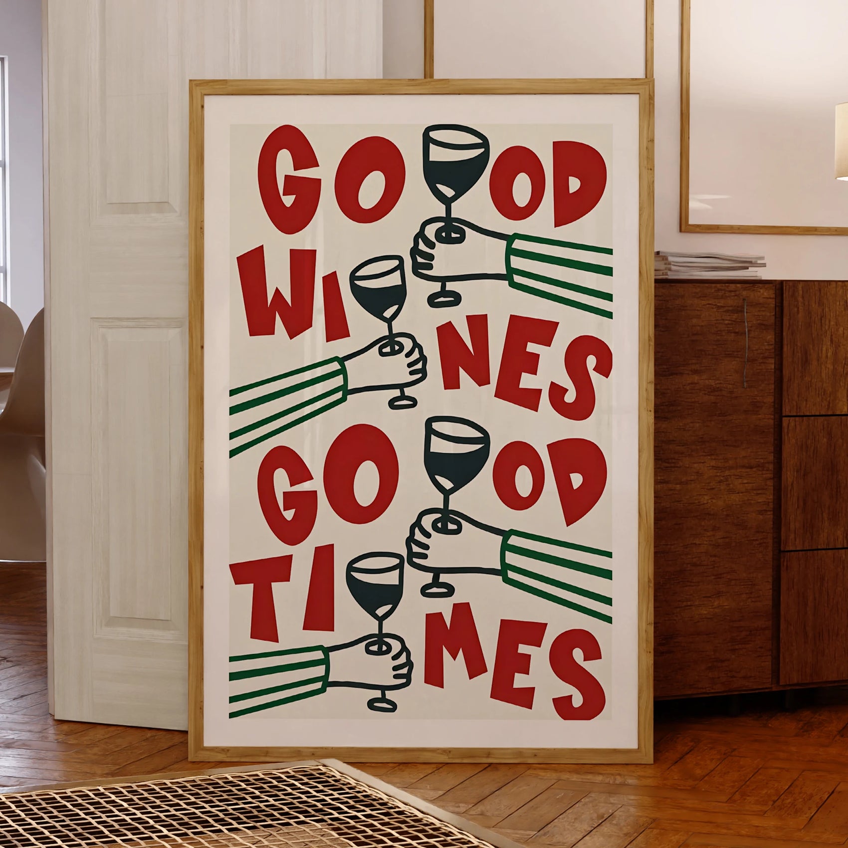 Framed poster with 'Good Wines Go Good Times' text and wine glass illustrations in a room.