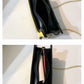 Black handbag with gold chain strap on a light background