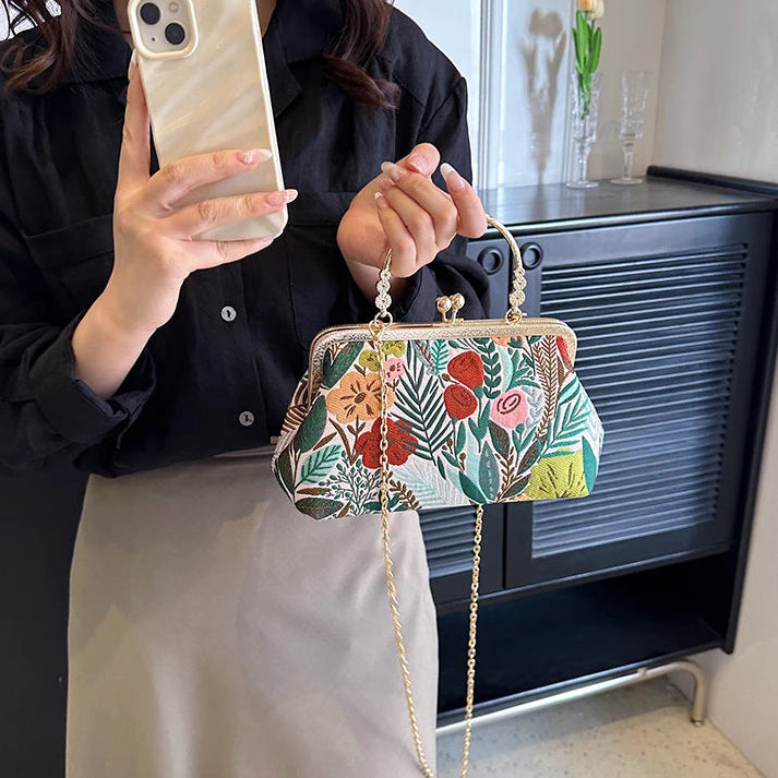 Person holding a floral handbag in front of a television.