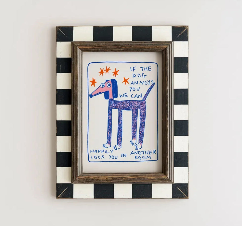 Framed artwork with a dog illustration and text on a white wall