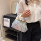 Person holding a floral handbag in front of a Tom Ford shelf.