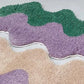 Wavy-patterned carpets in purple, green, and beige on a light gray background