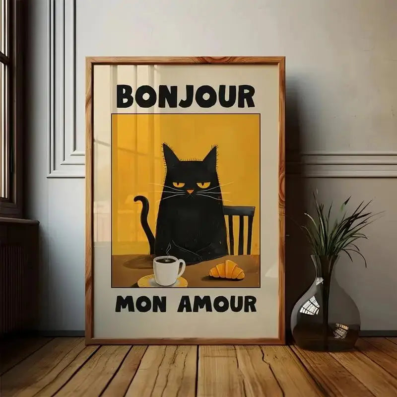 Framed artwork with a black cat, coffee cup, and croissant on a yellow background with 'Bonjour Mon Amour' text.