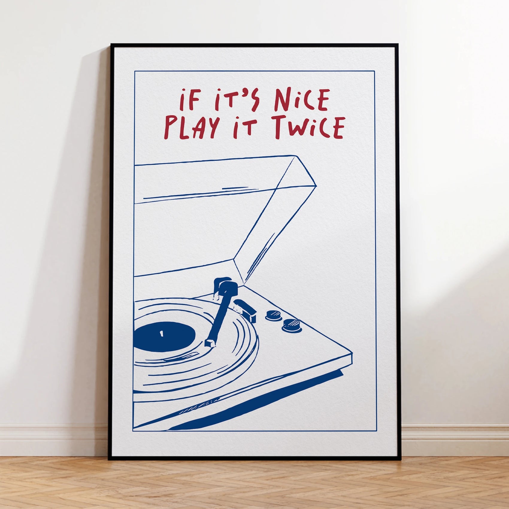Framed poster with a turntable illustration and text 'If it's nice play it twice' on a white wall.