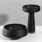 Two black ceramic bowls on a gray background