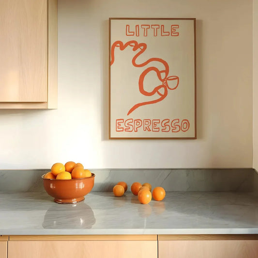 Kitchen counter with a bowl of oranges and a 'Little Espresso' poster on the wall.