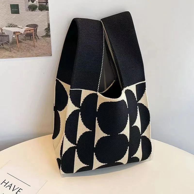 Black and white patterned bag on a light surface with a blurred background