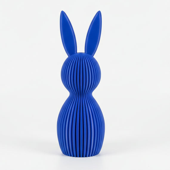 Blue rabbit-shaped object on a textured surface with a neutral background