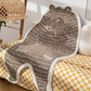 Bear-patterned blanket draped over a yellow and white checkered chair