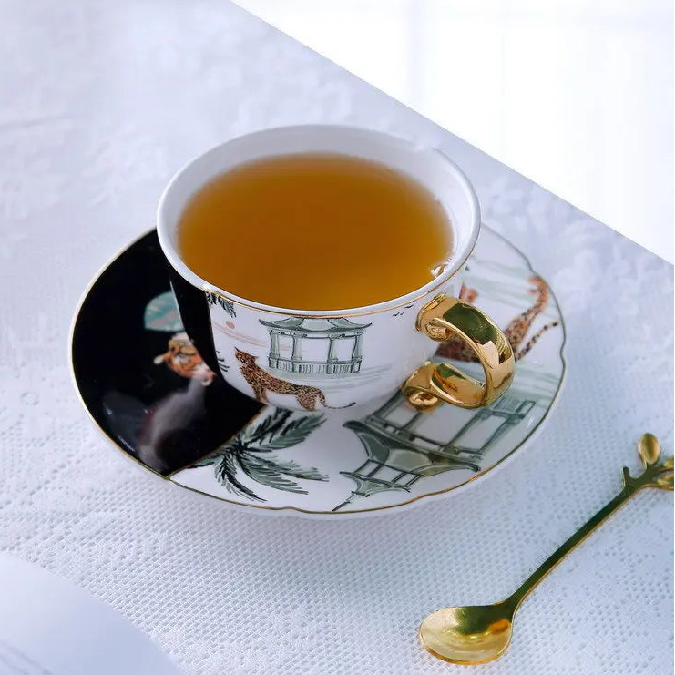 Tea cup with saucer featuring animal designs on a white surface