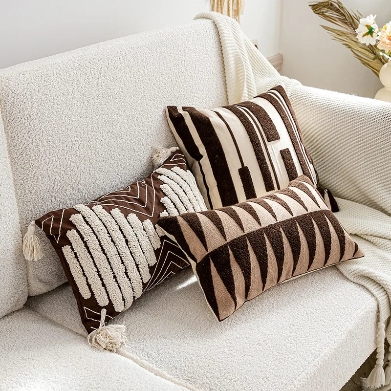 Decorative pillows with brown and beige patterns on a white sofa.