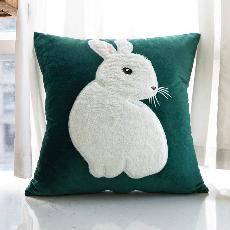 Green pillow with a white rabbit design on a white surface