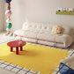 Modern living room with a yellow rug, white sofa, and colorful decor.