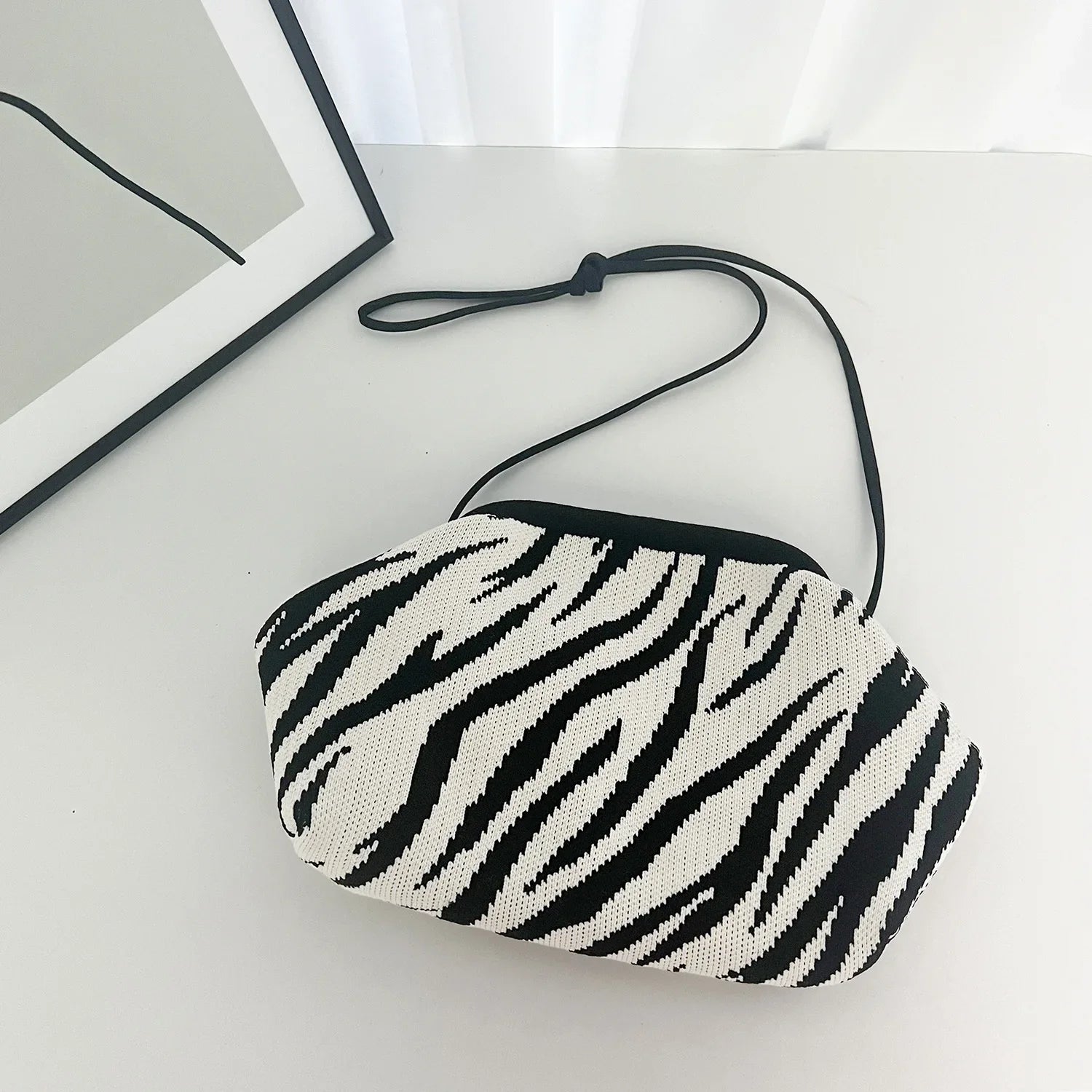 Zebra patterned pouch on a light surface with a blurred background