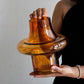 Person holding a large amber-colored glass object against a neutral background