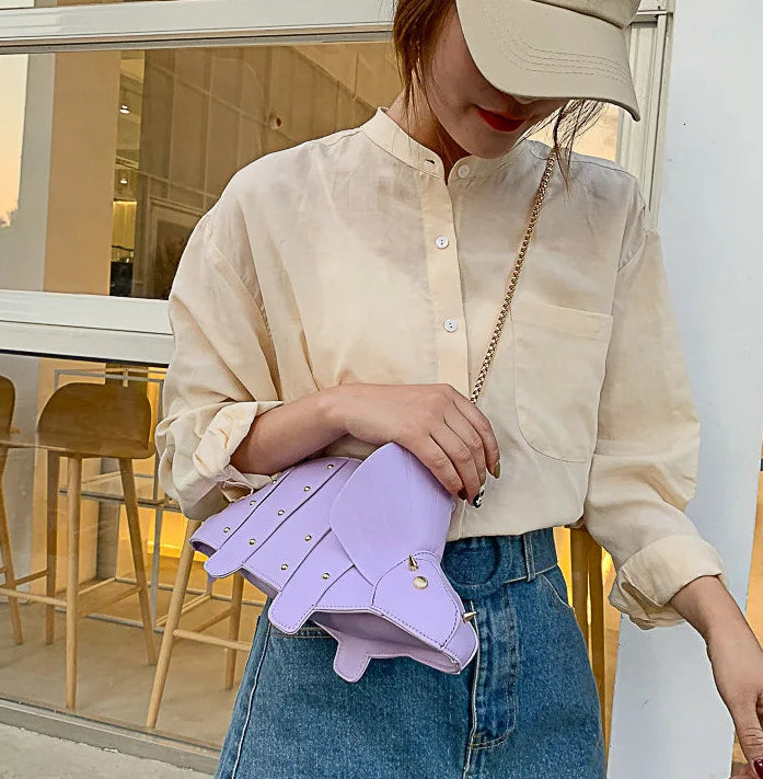 Person holding a purple handbag in an indoor setting