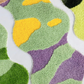 Colorful textured surface with green, purple, and yellow patterns