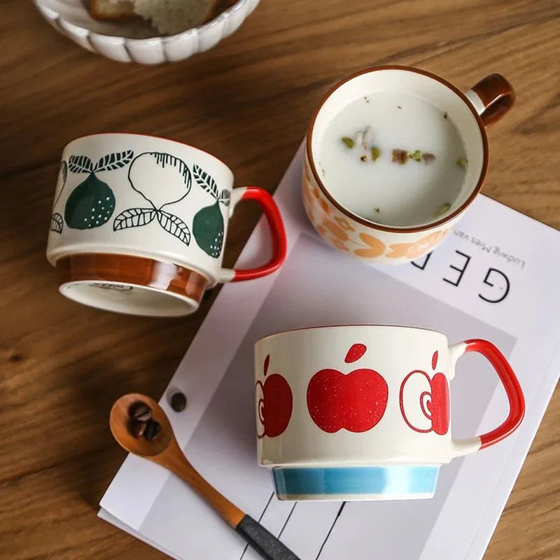 Three ceramic mugs with different designs on a wooden table.