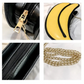 Black handbag with gold chain and yellow banana design on a white background