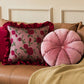 Decorative pillows on a brown sofa with floral and round designs