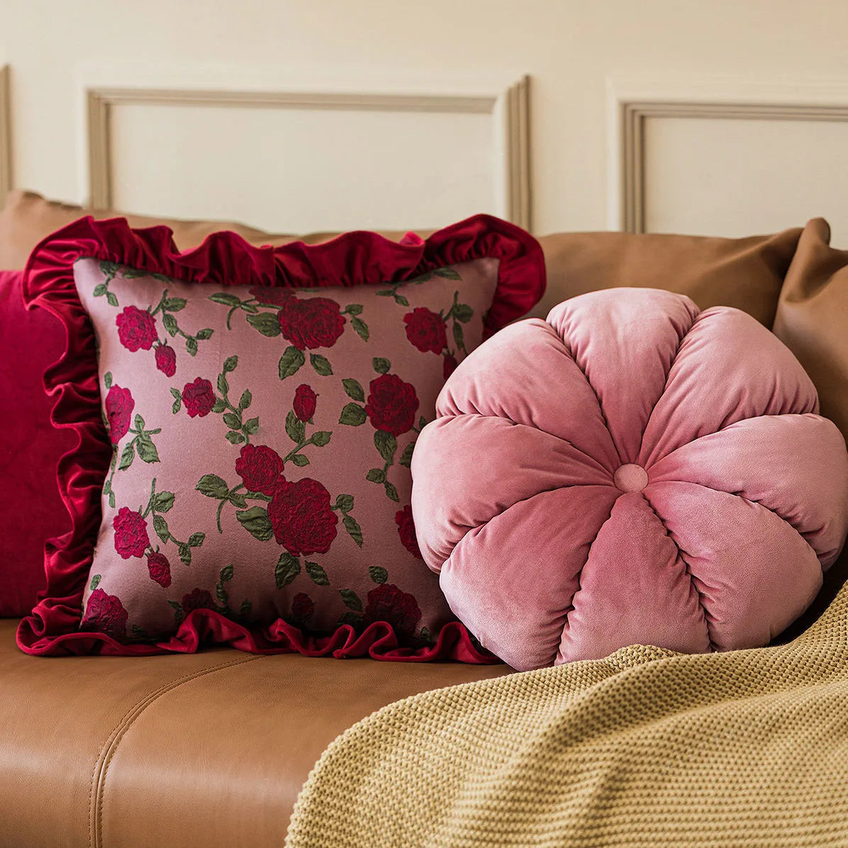 Decorative pillows on a brown sofa with floral and round designs