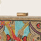 Decorative clutch bag with intricate patterns and colorful stones on a light gray background