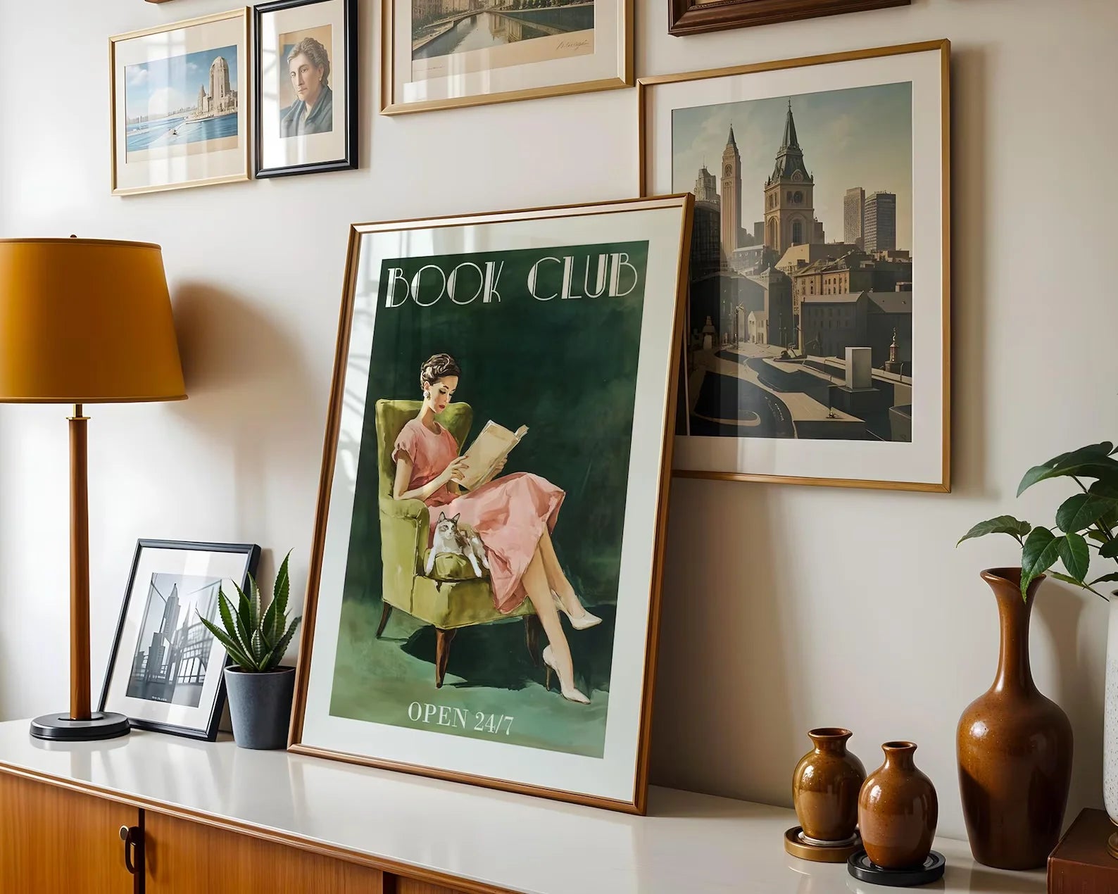 Framed poster of a woman in a book club with other framed pictures on a wall.