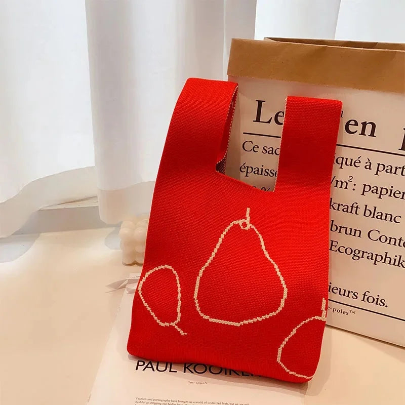 Red fabric pouch with pear design on a white surface