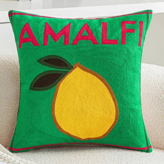 Green pillow with a lemon and 'AMALFI!' text on a couch