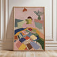 Framed artwork of a person reading a book on a colorful couch with books scattered around, in a room with a lamp and plant.