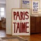 Decorative sign with 'PARIS je T'AIME' in a room with wooden furniture and framed art on the wall.
