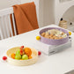 Two bowls on a table, one with fruits and the other with snacks, in a home setting.
