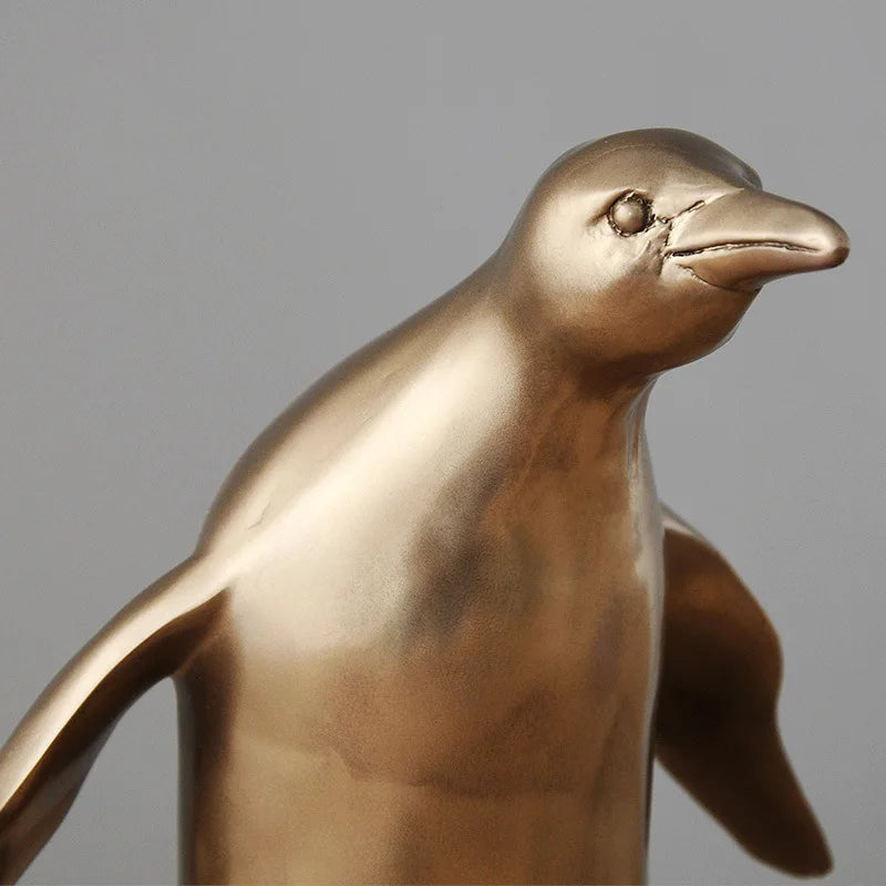 Bronze penguin sculpture on a gray background