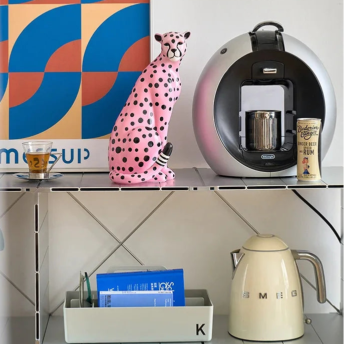 Modern kitchen shelf with coffee machine, decorative items, and a colorful abstract painting.