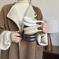 Person holding a stack of ceramic cups with a neutral background