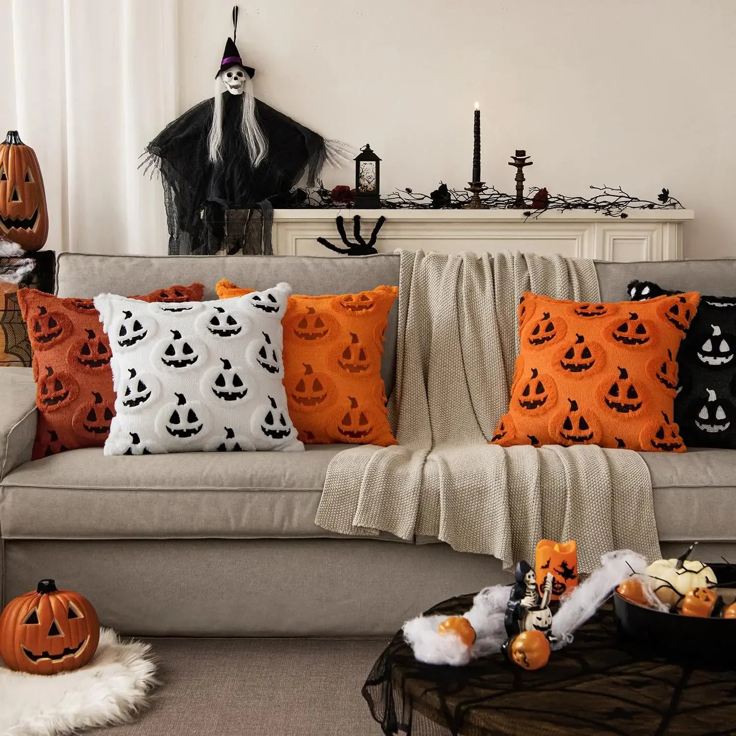 Halloween-themed living room with decorative pillows and pumpkins.