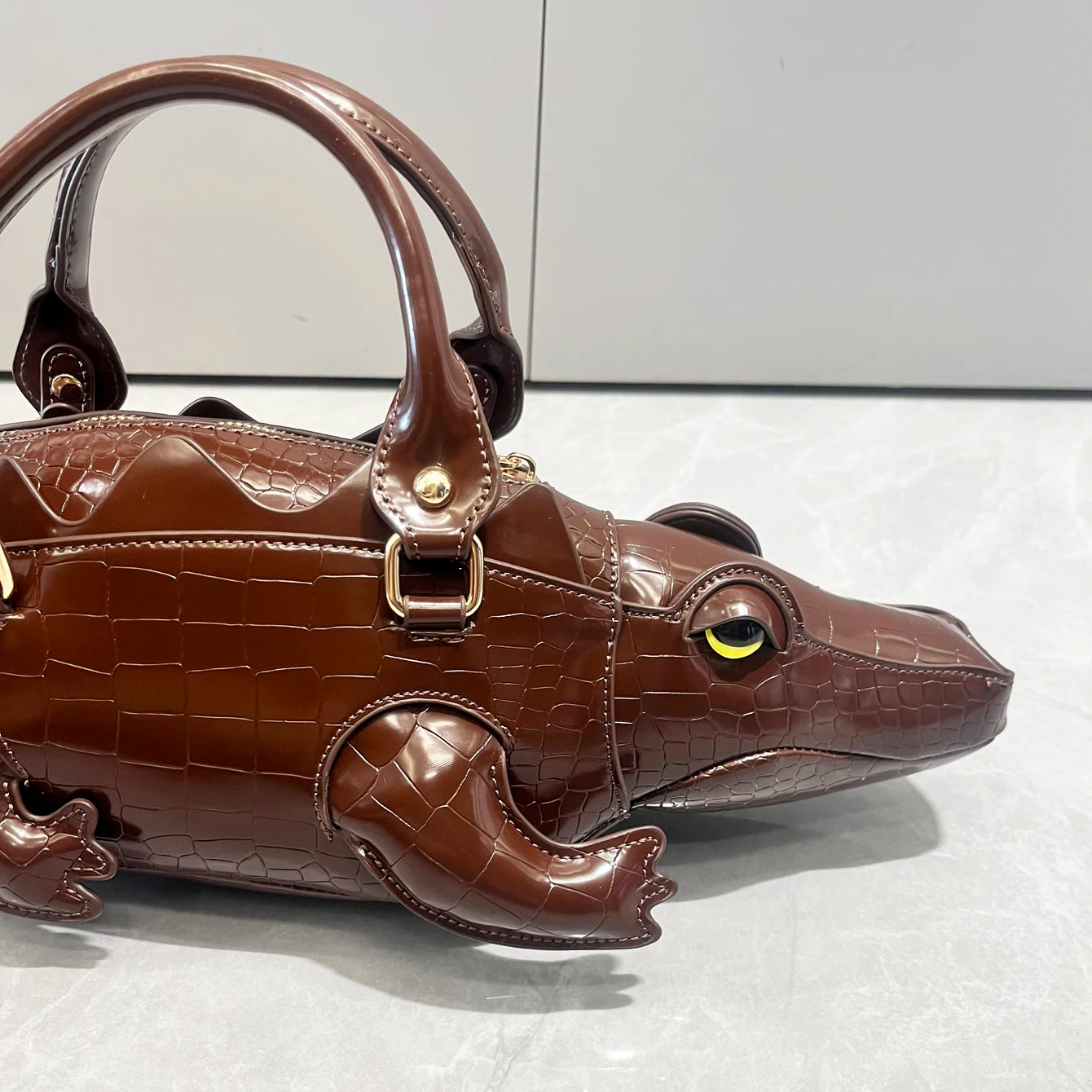 Brown frog-shaped handbag on a light gray background