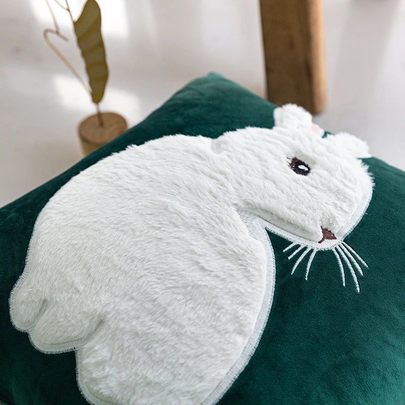 White cat-shaped towel on a green cushion with a blurred background