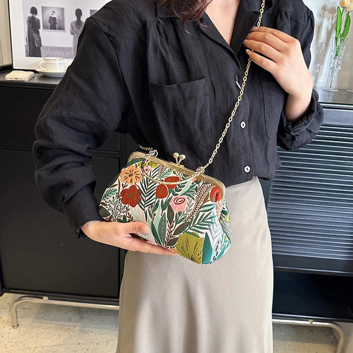 Person holding a floral clutch bag in an indoor setting