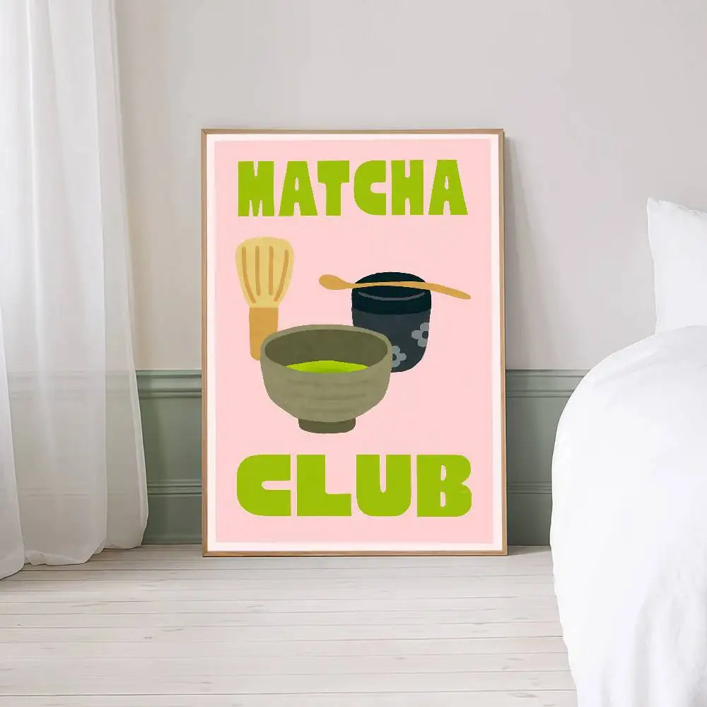 Framed poster with 'Matcha Club' text and matcha preparation elements on a pink background, placed on a surface.