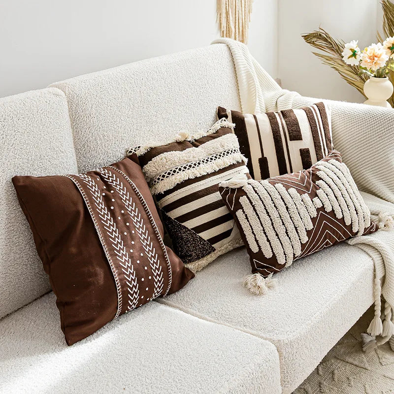 Decorative pillows with brown and beige patterns on a white sofa.