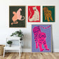 Four colorful animal posters on a wall with a small table and plants below.