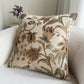 Floral patterned pillow on a sofa with a neutral background