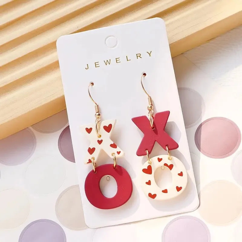 Jewelry card with red and white 'XO' earrings on a light background